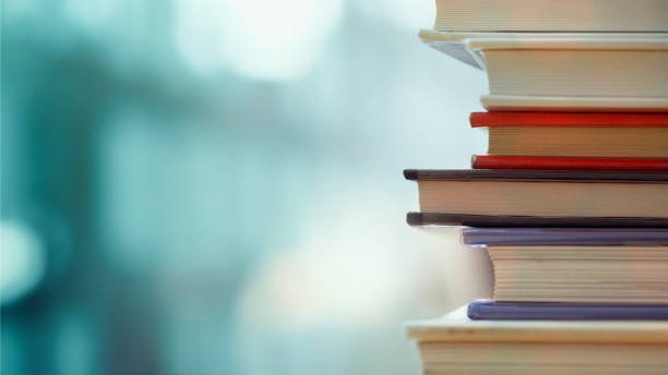 istockphoto-671101136-612×612-1 Book stack in the library room and blurred bookshelf, business and education background