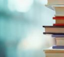 Book stack in the library room and blurred bookshelf, business and education background